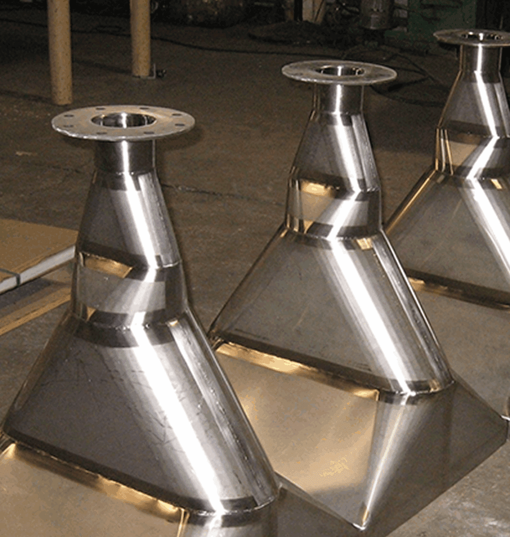 Metallic funnel-shaped industrial components on floor.