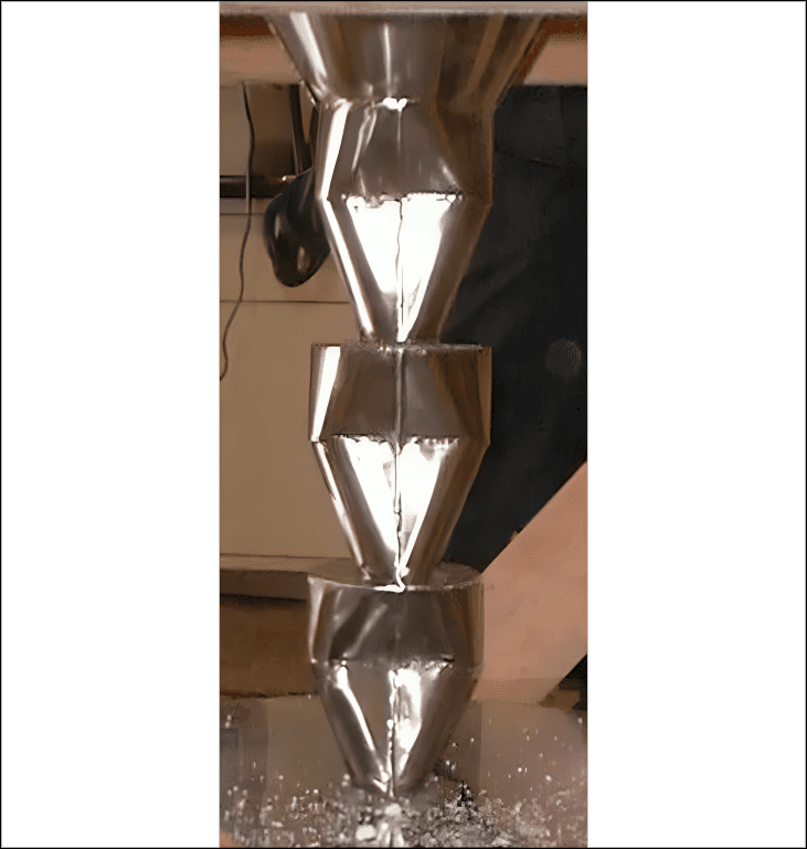 Stacked metallic funnels with flowing liquid.