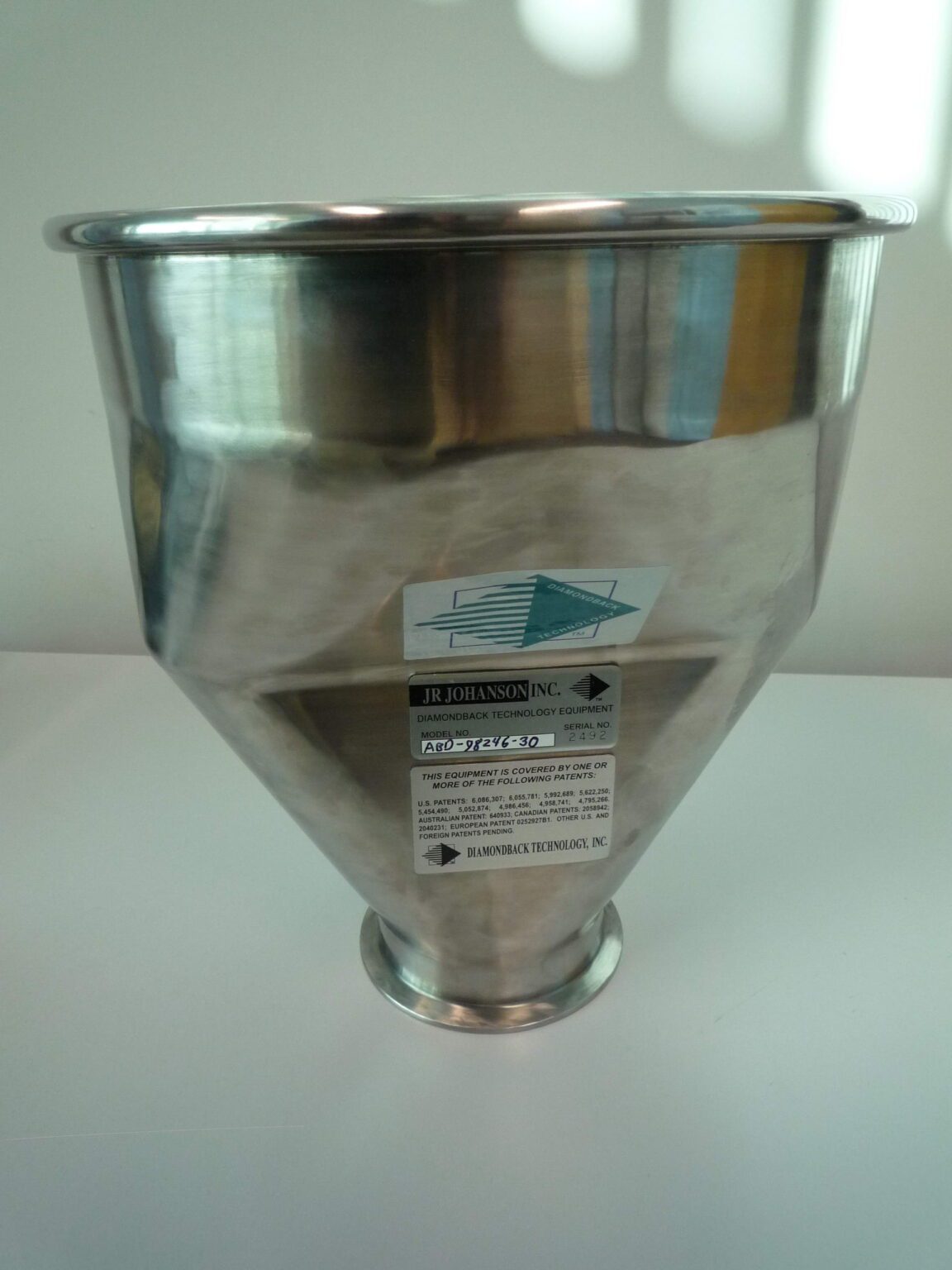 Metal funnel with a label attached.